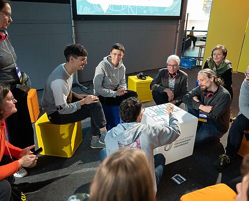 Workshop-Teilnehmende sitzen im Kreis und tauschen sich aus