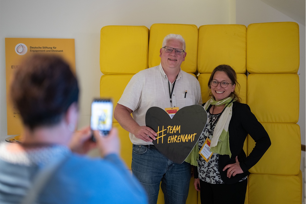 Foto von zwei Personen mit einem Schild in Herzform mit dem Text #TeamEhrenamt