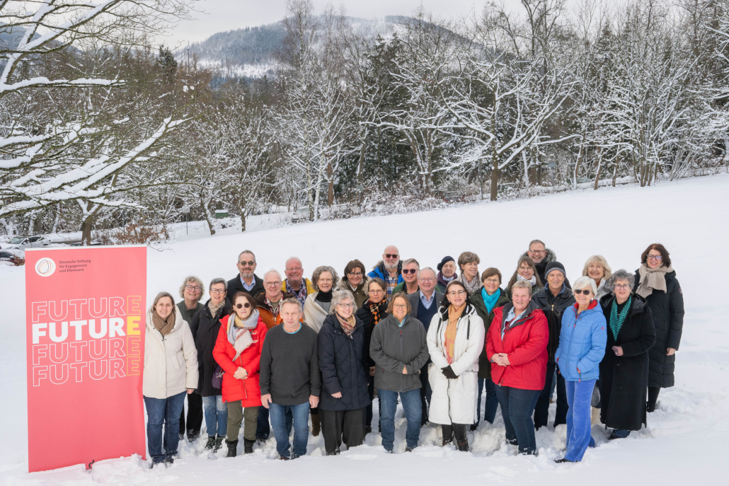 Gruppenbild mit älteren Erwachsenen des 5. Jahrgangs des FuturE Programms im Schnee an enem Hügel mit Wald im Hintergrund